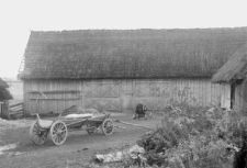 A new wagon next to a barn