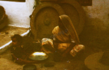 Woman with child preparing food (Iconographic document)